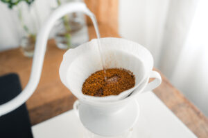 Water pouring from a gooseneck kettle into a pour over cone.