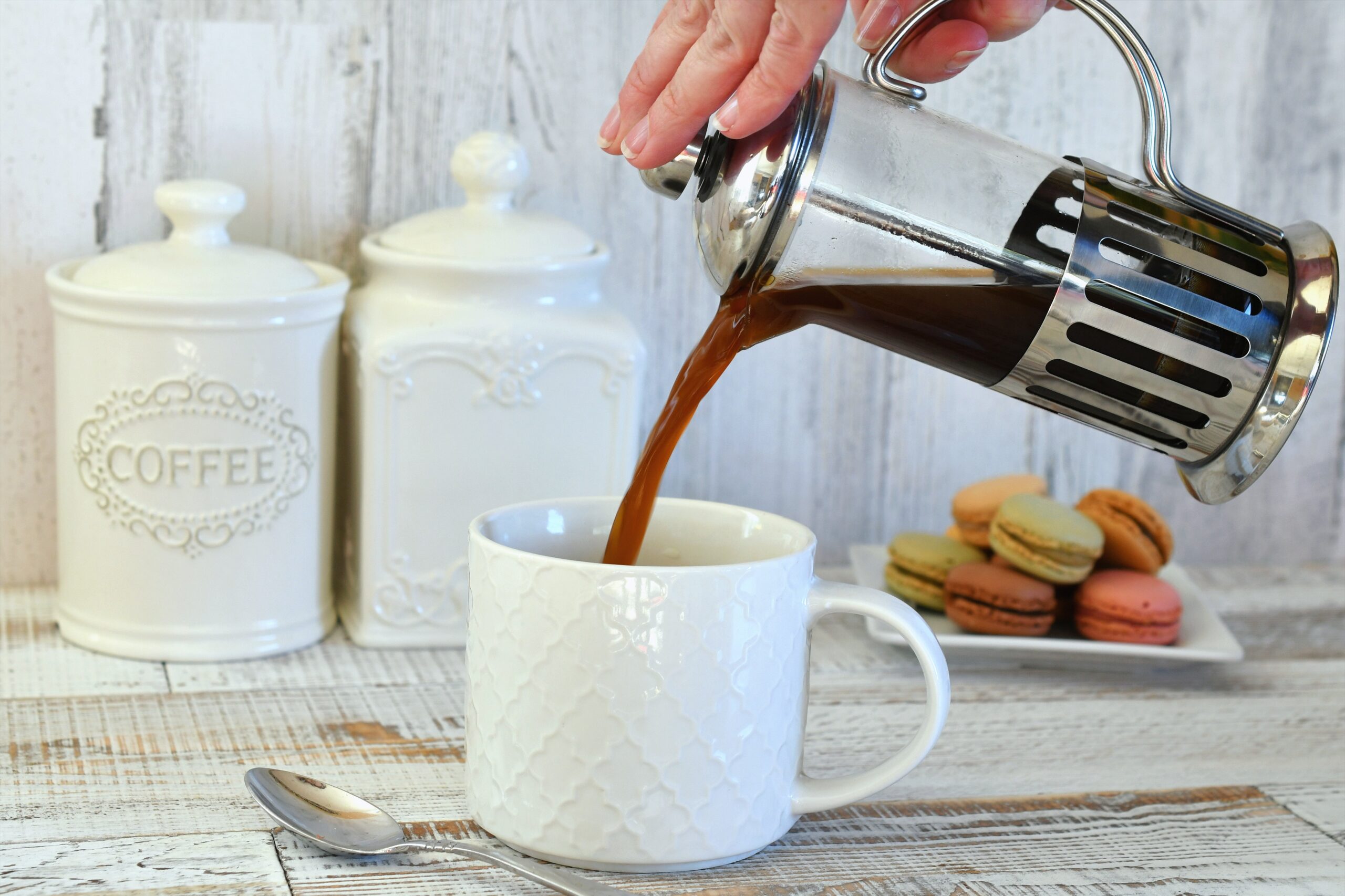 pouring-coffee-from-french-press-coffee-maker-into-2022-11-14-03-49-07-utc A person pouring coffee from a French press into a white coffee mug.